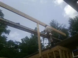 Carpenter setting a ridge beam over a new addition frame — Ice Dam Removal by Roofing Brothers in Sellers