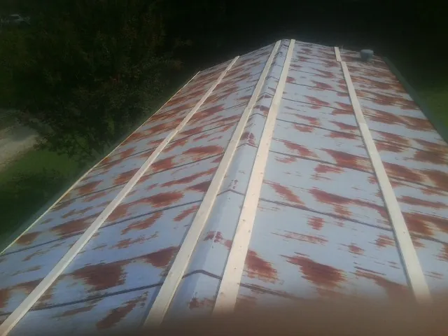 Rusted metal roof panels with new wood purlins before replacement — Storm Damage Roof Repair in Sellers by Roofing Brothers