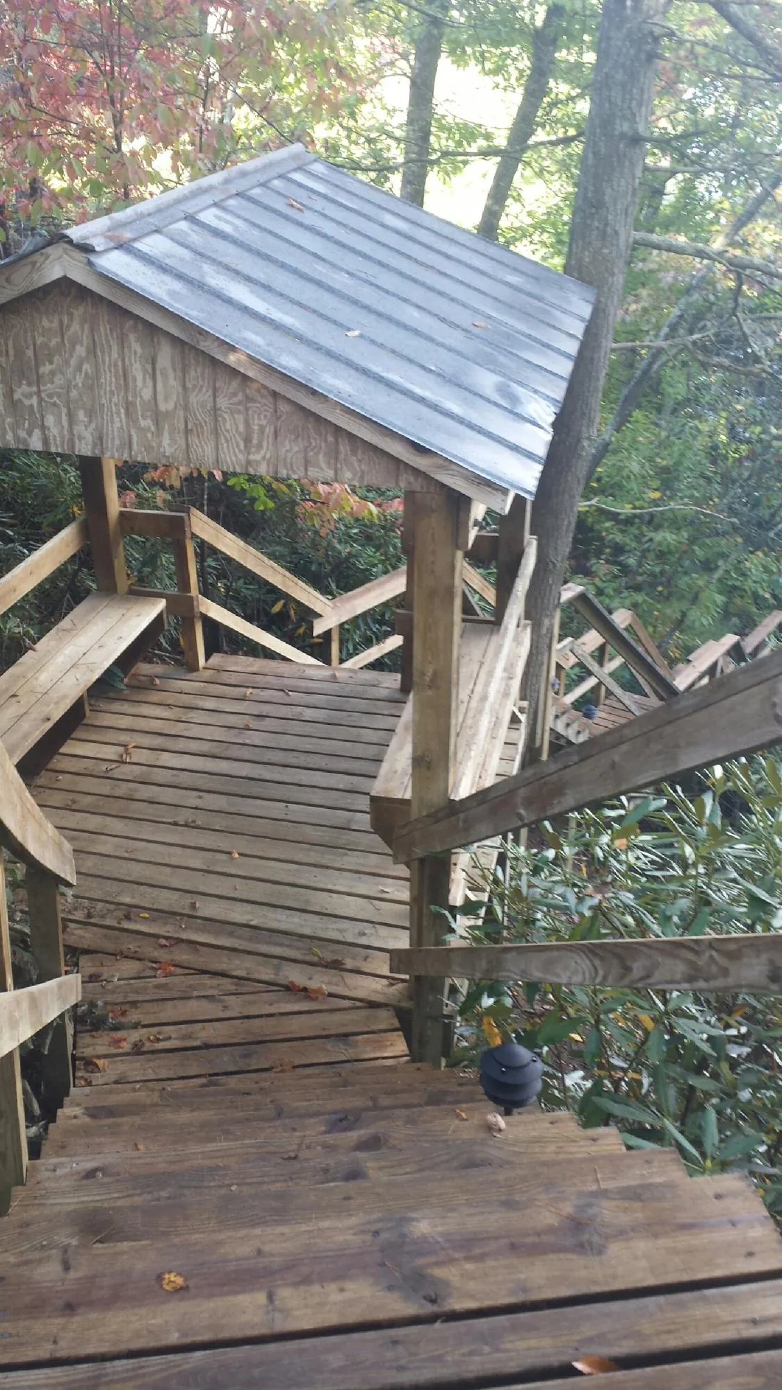 Metal roofed shelter over wooden steps on a wooded walkway — Skylight Repair & Installation work by our crew in Sellers
