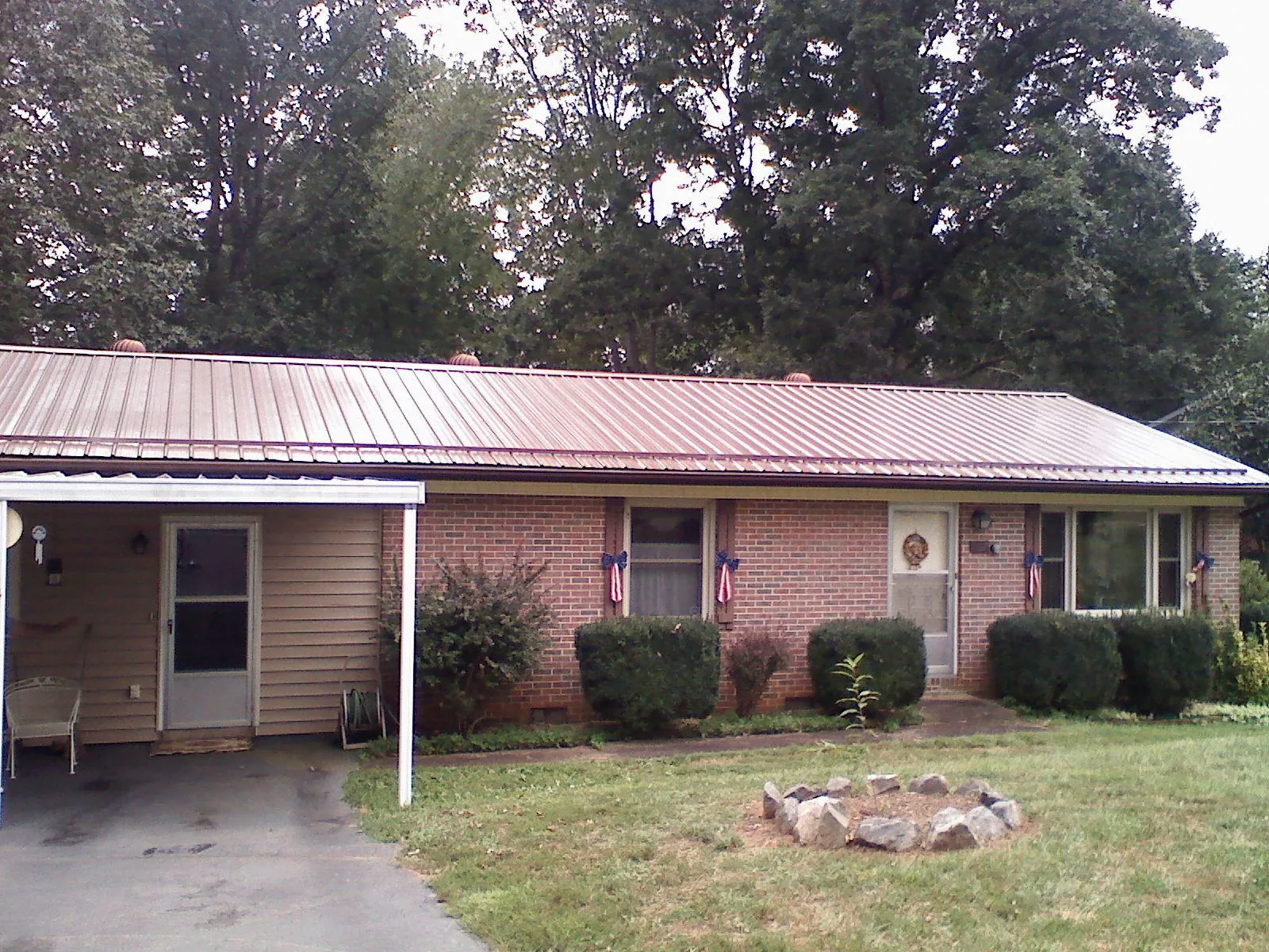 Bronze metal roof and carport on a brick ranch home — Roof Repair work by our crew in Sellers